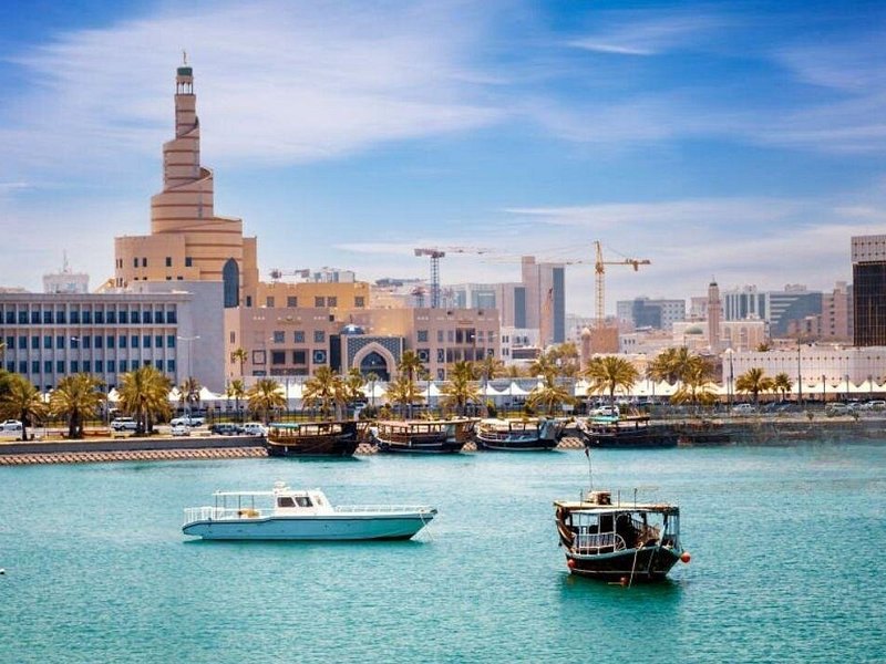 Boats on the water in front of the spiral minaret of the Fanar centre in Doha
