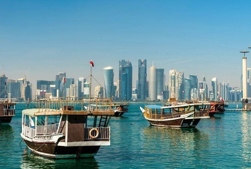 Wooden dhow boats moored on Doha Bay with the West Bay towers behind