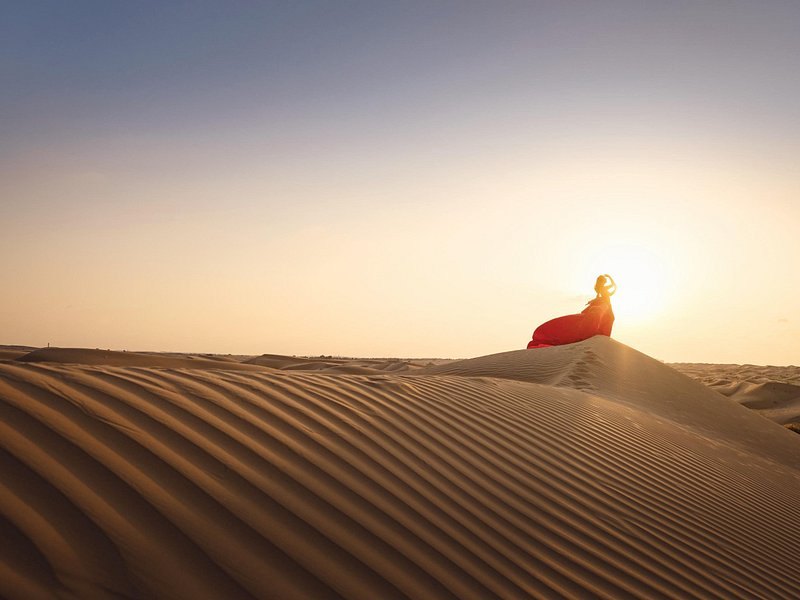 Wind-carved sand dunes in the Qatari desert at sunrise